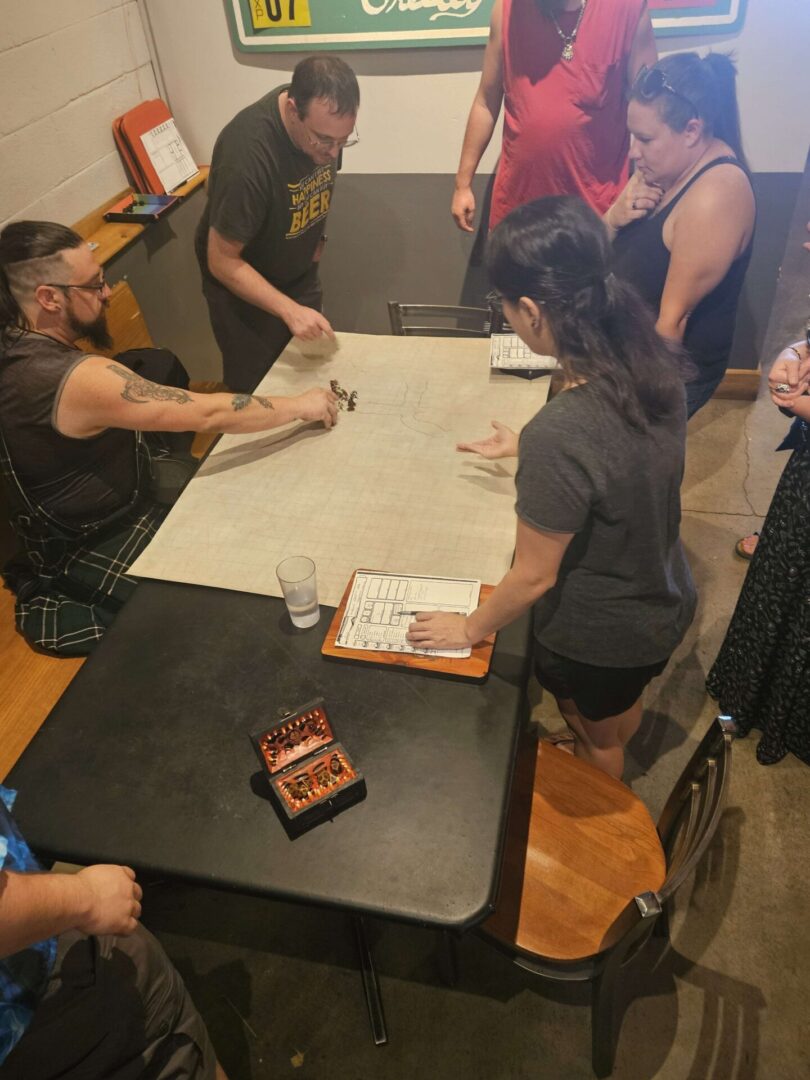 People gathered around a table working on a large paper or project.