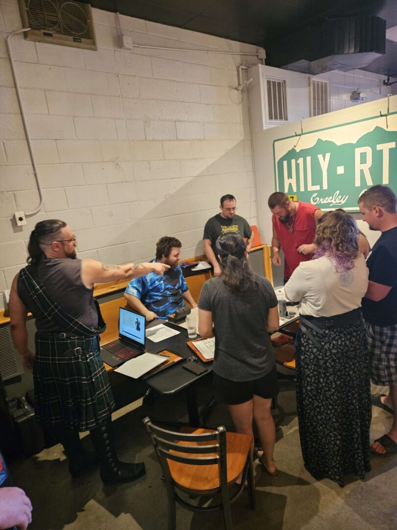 People gathered around a table with laptops in a casual indoor setting.